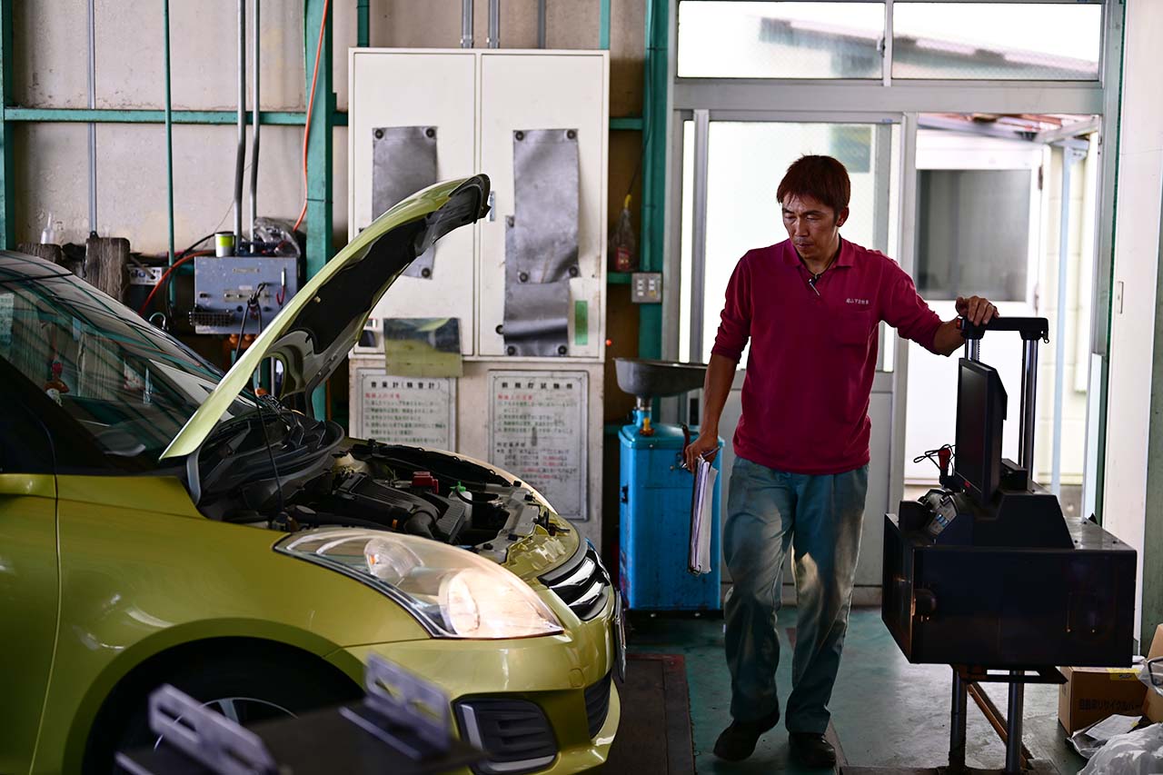 診断機でチェックする整備士
